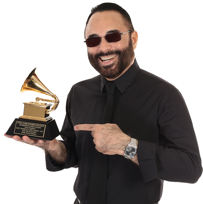 Roberto Delgado dressed in black holding a Grammy in his hand