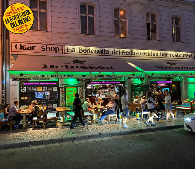 Night shot of the neon green facade of the Bodeguita del Medio in Prague