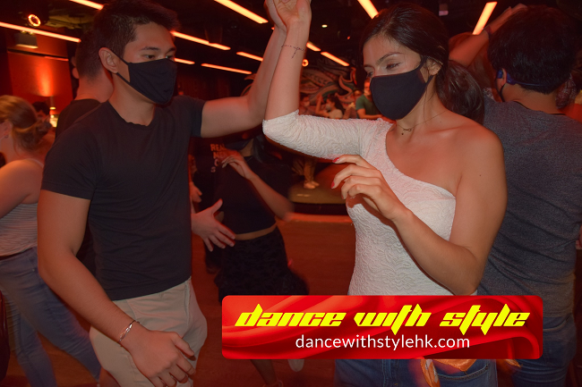 Couple dancing salsa with masks