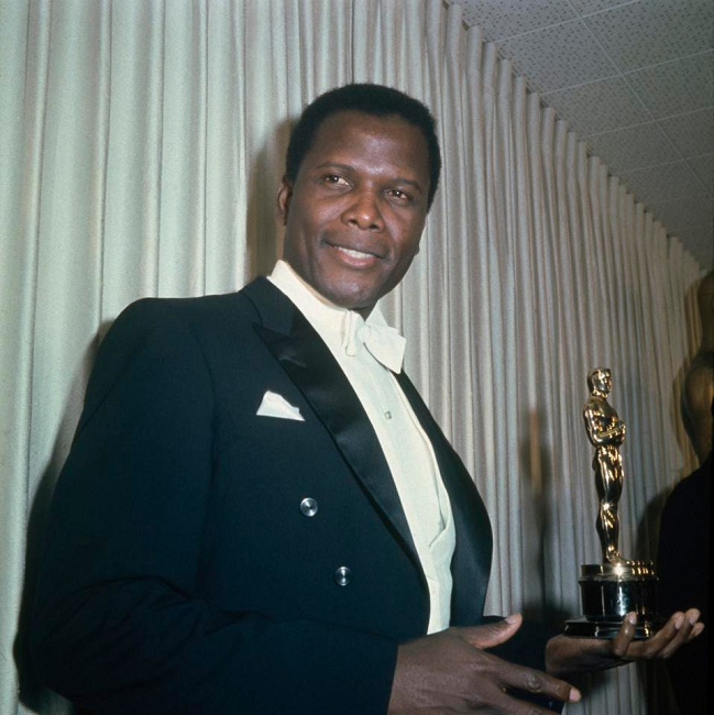 Sidney Poitier dressed in a suit with the Oscar in his hand