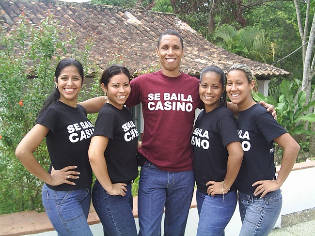 Pedro González with burgundy flannel and four women on the sides